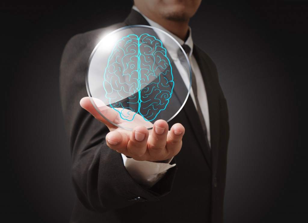 Businessman shows a brain in shield glass as concept