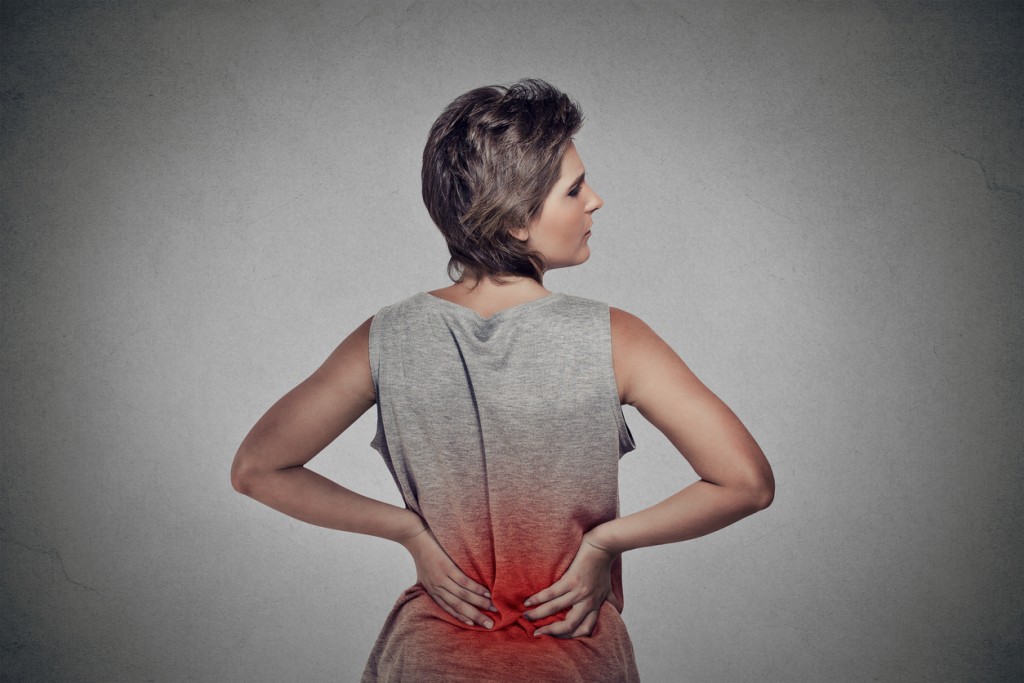Woman with backache lower back pain colored in red