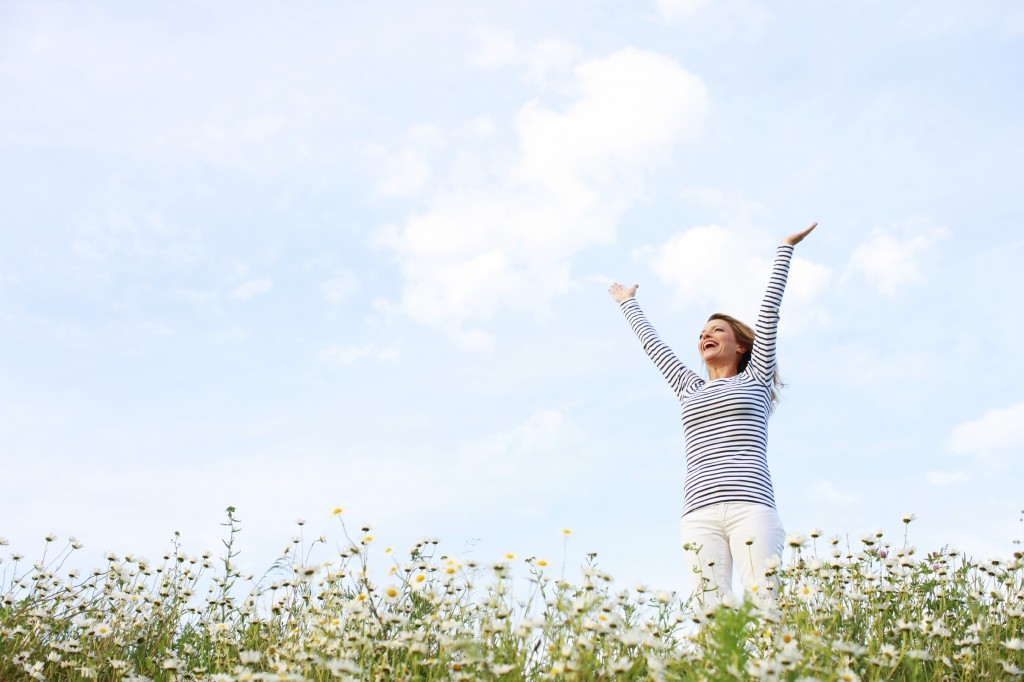 Woman with stretched arms in flower field