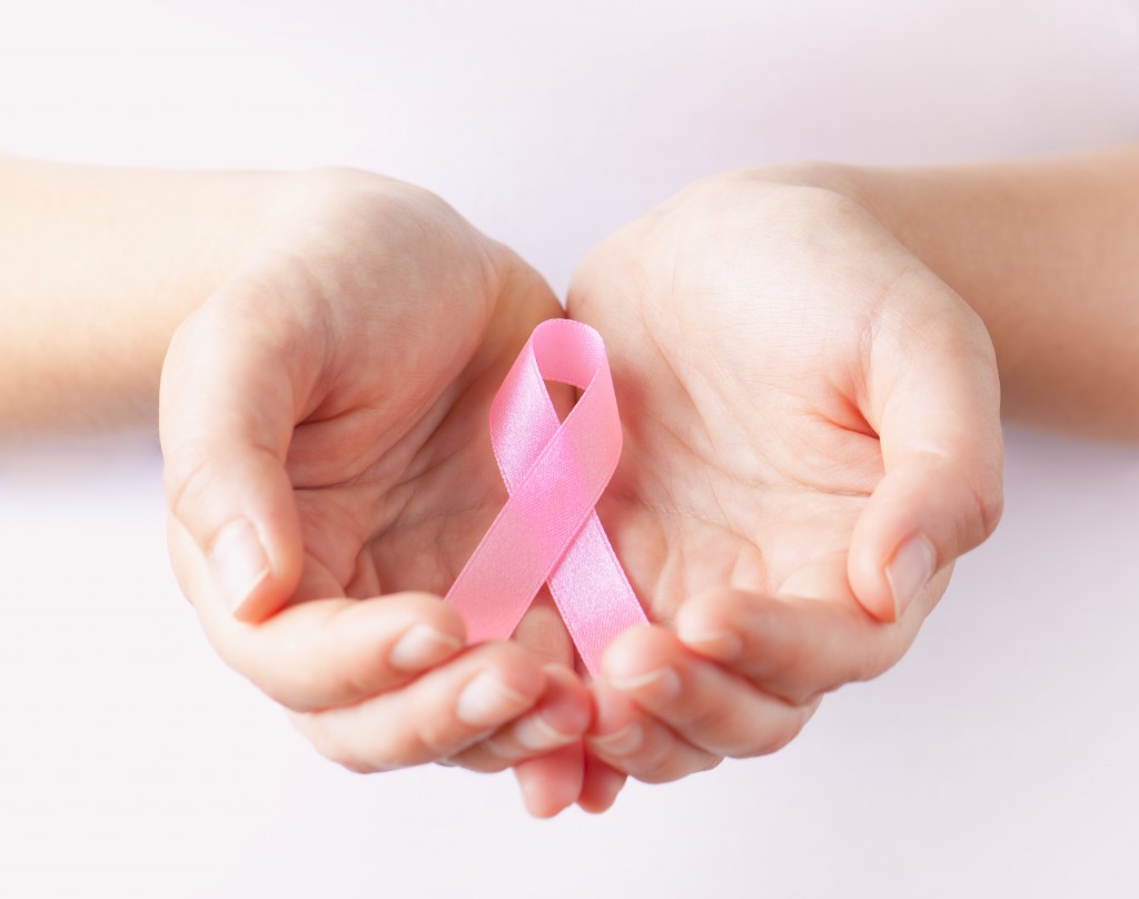 holding pink breast cancer awareness ribbon