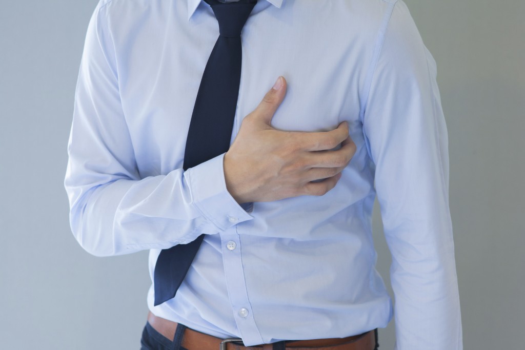 Man having heart-attack / chest pain in isolated background